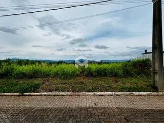 Vista da propriedade com vegetação e paisagem ao fundo.