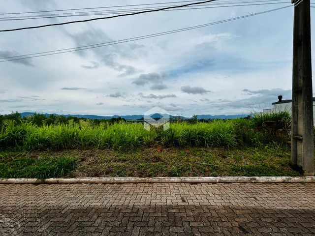 Vista da propriedade com vegetação e paisagem ao fundo.