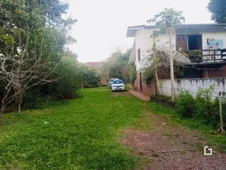 Área gramada com vegetação ao redor da propriedade.