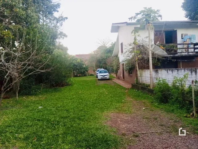 Área gramada com vegetação ao redor da propriedade.