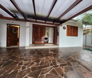 Área comum com piso de pedra e vigas de madeira expostas.