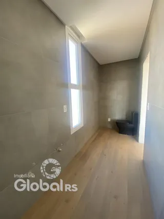 Corredor interno com piso de madeira e janela em uma residência.