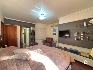 Quarto com cama e armário de madeira em um imóvel no Brasil.