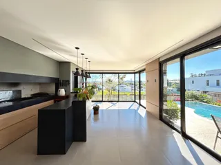 Vista de uma cozinha moderna com portas de vidro que dão acesso a uma área externa.