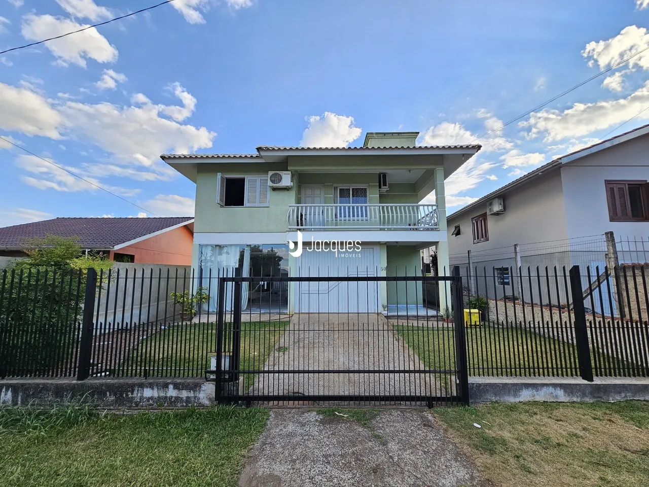 Fachada de uma casa em Lajeado, Brasil, com cerca e portão de ferro.