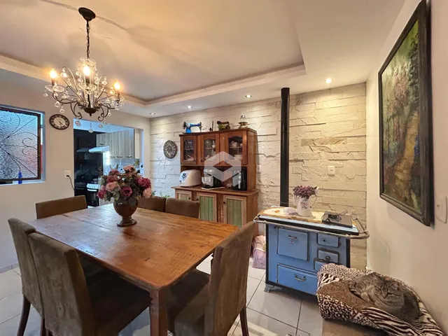 Foto de uma sala de jantar com mesa de madeira e painel de pedra.