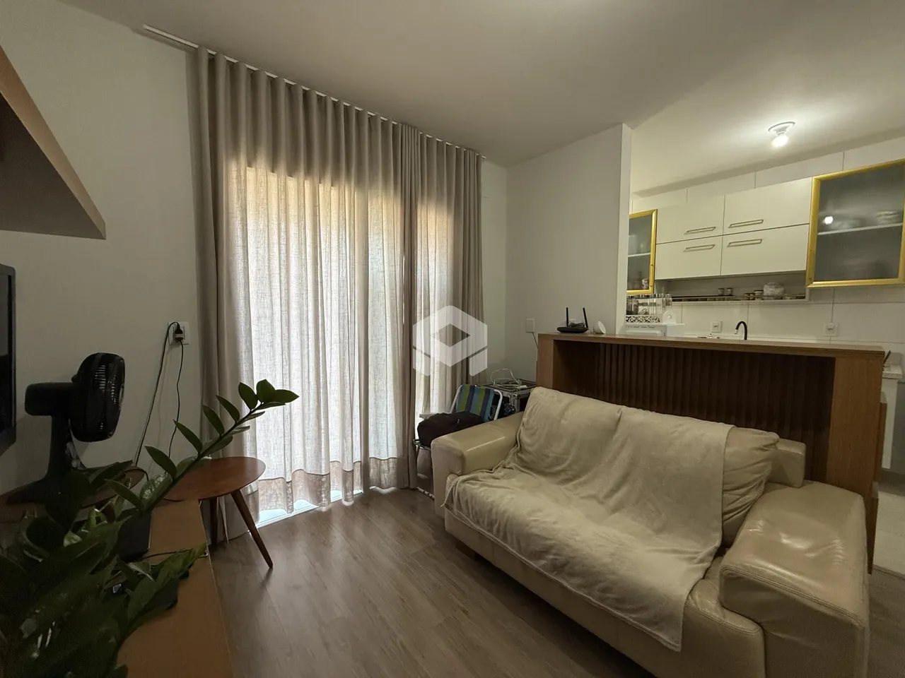 Sala de estar com janela e cortinas claras em um imóvel no Brasil.