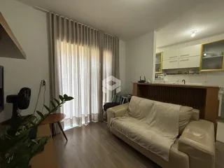 Sala de estar com janela e cortinas claras em um imóvel no Brasil.