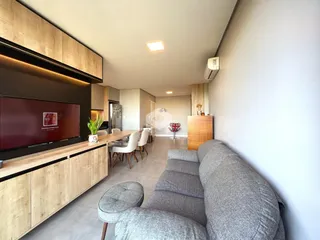 Sala de estar moderna com ambiente integrado de cozinha e jantar.