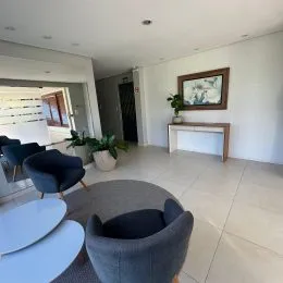 Sala de estar com poltrona de design e piso claro.