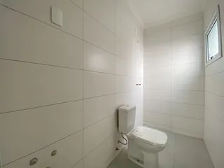 Foto interna de um banheiro com paredes brancas e piso claro.