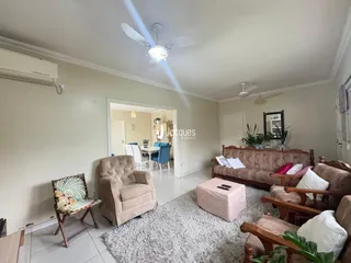 Sala de estar com sofá e poltronas em ambiente claro.
