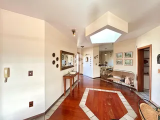 Hall de entrada com piso de madeira e paredes claras.