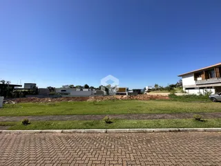 Vista aérea de uma área verde com construções ao fundo.