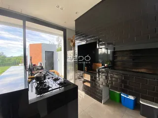 Vista da cozinha moderna com bancada escura e janela ampla.