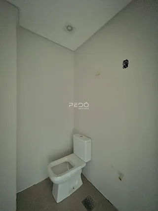 Hall de passagem com vaso sanitário em ambiente interno.