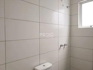 Parede revestida com azulejos brancos em um banheiro.