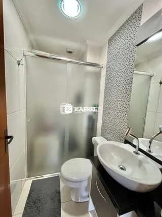 Um banheiro com revestimento branco e um vaso sanitário é visível na propriedade.