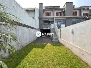 Fachada de um prédio residencial em Lajeado, Brasil, com jardim gramado em primeiro plano.