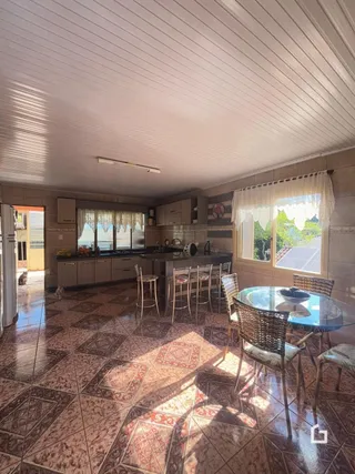 Sala de jantar com piso de cerâmica e janela iluminada.