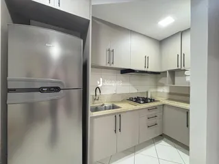 Interior de uma cozinha moderna com armários cinzas e bancadas claras.