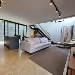 Foto de uma sala de estar com sofá e escadaria.