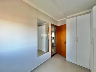 Hall de entrada com paredes brancas e armários brancos.