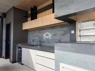 Foto de uma cozinha moderna com armários brancos e bancada escura.