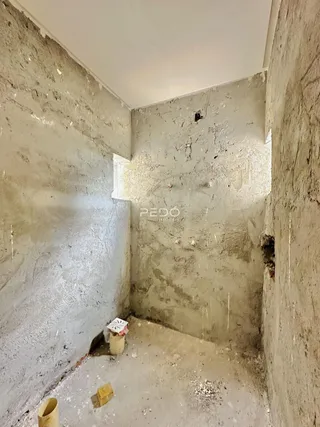 Corredor interno com paredes de reboco áspero.