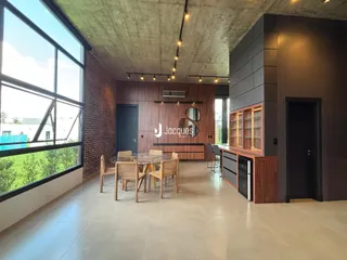 Ambiente interno moderno com grande janela e vista para a natureza.