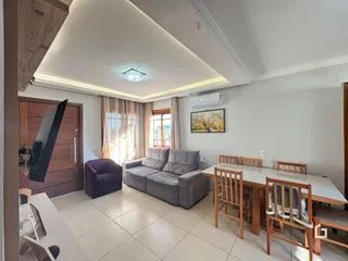 Sala de estar com sofá e mesa de jantar em um imóvel no Brasil.