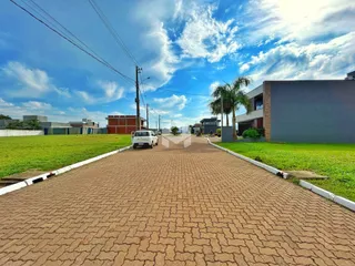 Vista da entrada de uma propriedade em Lajeado, Brasil com gramado e estrada pavimentada.