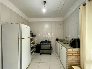 Foto de uma cozinha com revestimento de cerâmica branca e armários brancos.