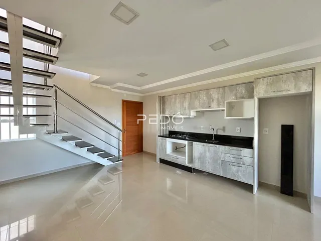 Interior de uma sala de estar com cozinha e escadaria em um imóvel em Lajeado.