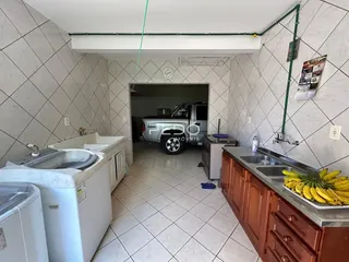 Interior de uma cozinha com revestimento de cerâmica e armários de madeira.