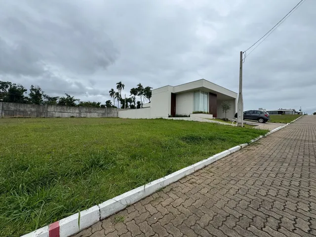 Foto da fachada de uma casa branca com um grande gramado em Lajeado.
