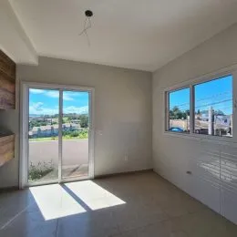 Foto do interior de uma sala com porta de vidro que oferece vista externa.