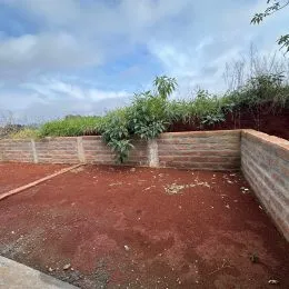 Vista de um terreno com muro de contenção de alvenaria.