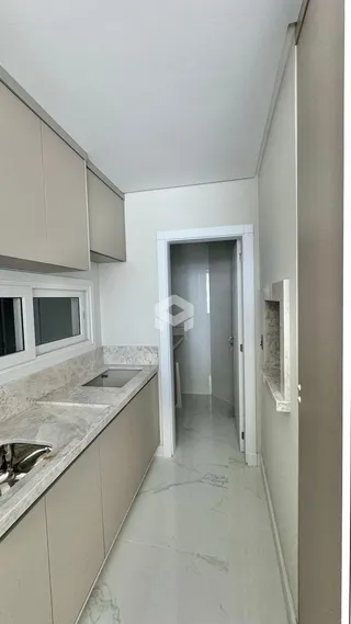 Vista interna de um corredor com armários e bancadas em um imóvel.
