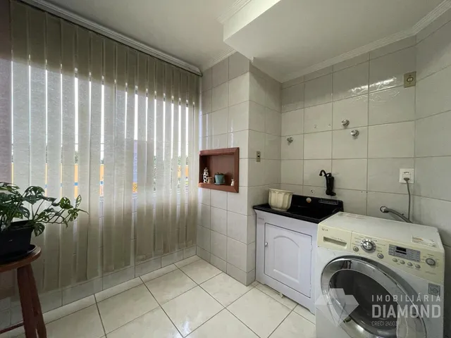 Interior de um cômodo com piso de cerâmica e janela coberta por persianas.