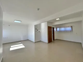 Interior de uma sala ampla e clara com piso de cerâmica.