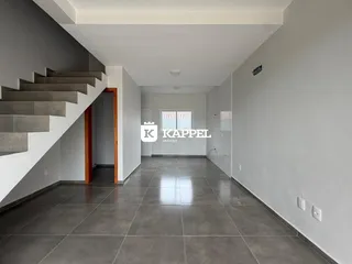 Hall de entrada com escadaria e piso de cerâmica em um imóvel.
