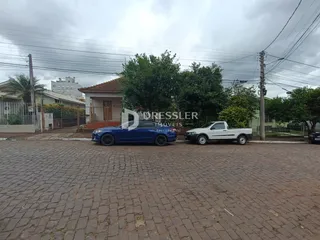 Vista externa de uma residência em Lajeado, Brasil, com veículos estacionados na frente.