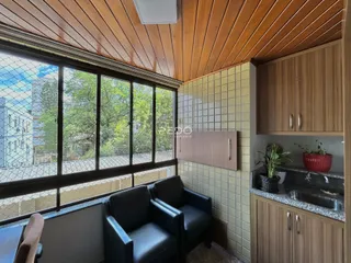 Sala de estar com grandes janelas e forro de madeira.