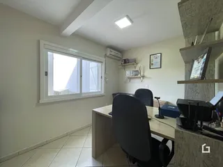 Ambiente interno de um cômodo com janela e área de trabalho em um imóvel.