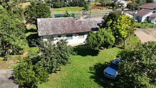 Fachada de uma residência com telhado de telhas e jardim gramado.