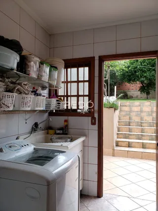 Cozinha com paredes de azulejo e janela de madeira.