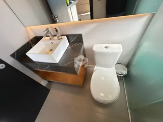 Foto de um banheiro moderno com pia e vaso sanitário.