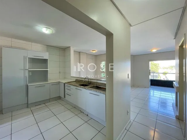 Vista interna de uma cozinha com piso de cerâmica branca.