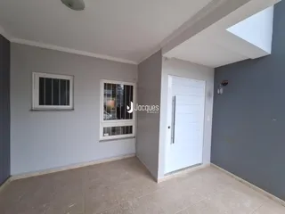 Foto de um corredor interno com paredes cinzas e piso de cerâmica.
